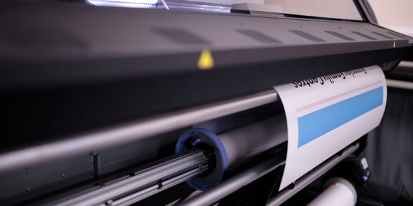 Beginning of a poster being printed on a large format printing machine