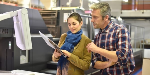 Man in printing house showing client printed documents-719722-edited