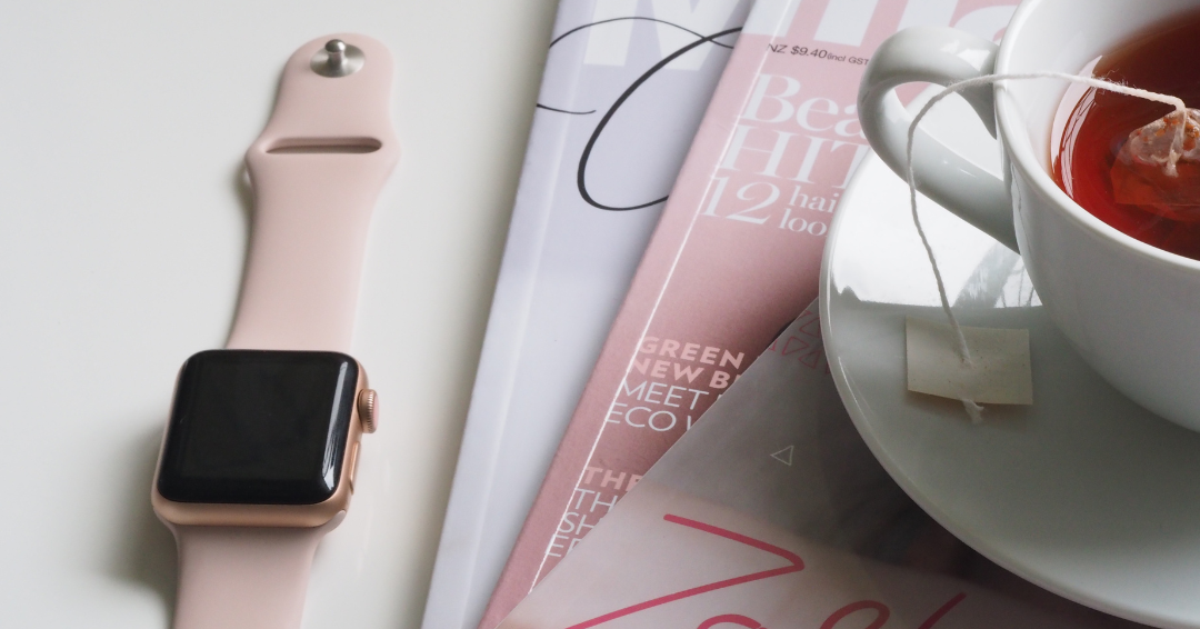 a digital watch placed next to some print materials
